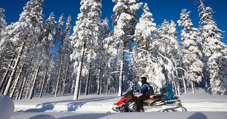 The tourist enjoys exploring in Whitefish, Montana using Snowmobile