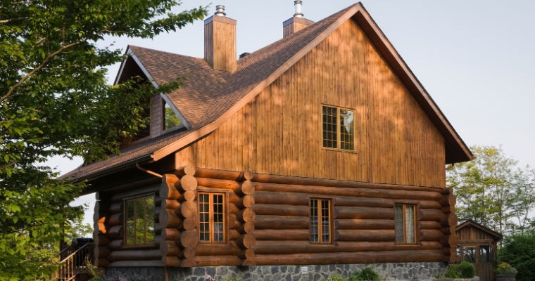 Log home surrounded by nature, with a stone walkway leading to the entrance, at Haymoon Resort in Whitefish, Montana.