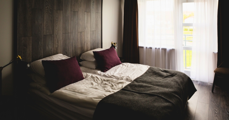 A stylish bed with two pillows and a wooden headboard, representing the comfort of The Firebrand Hotel in Whitefish, Montana.