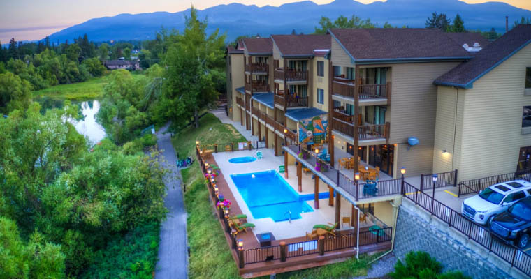 Aerial view of The Pine Lodge with outdoor pool and overlooking view of the river