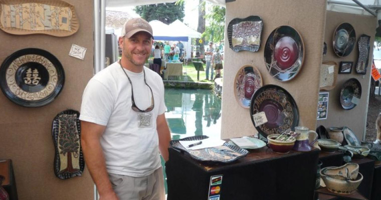 Tourist taking a picture with different arts during Huckleberry Days Festival