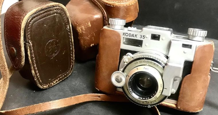 A vintage camera with a leather case and lens, displayed at the Stumptown Historical Museum in Whitefish, Montana.