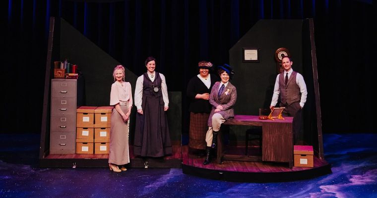 The cast of the Whitefish Theatre Company play performing on stage, featuring a woman and a man in the spotlight.