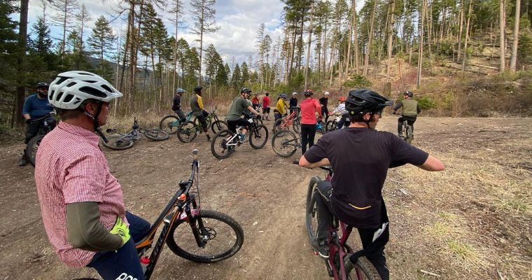 A group of mountain bikers navigating a dirt trail in the Flathead area, showcasing outdoor activities in Whitefish, Montana.