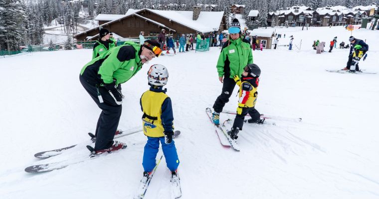 Children skiing with their mentor at Whitefish Mountain Resort, capturing the excitement of winter sports in Montana's scenic outdoors.