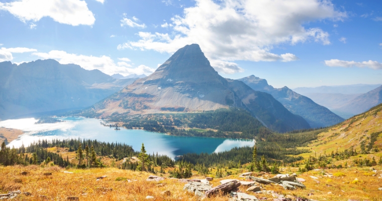 Scenic view of a mountain lake surrounded by majestic mountains in Glacier National Park, Whitefish, Montana.
