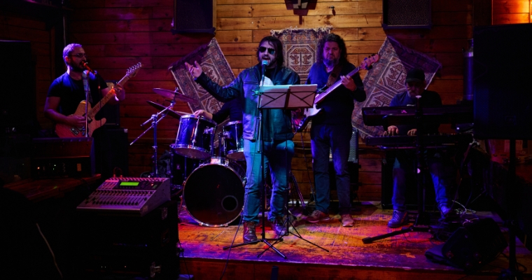 A band performs live music in a downtown Whitefish venue, featuring a microphone and an engaging atmosphere.