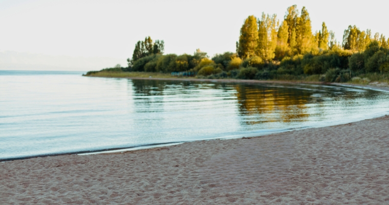 Tranquil Whitefish City Beach, featuring soft sand and calm waters, perfect for a peaceful stroll along the shore.