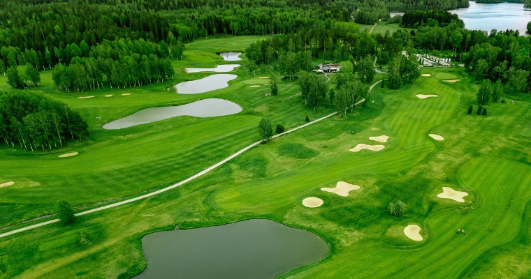 Aerial view of the lush green Whitefish Lake Golf Club, showcasing its well-maintained fairways and scenic landscape.