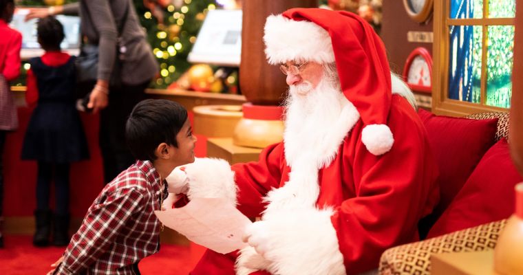 A child joyfully meet Santa Claus, capturing the festive spirit of Christmas in Whitefish, Montana.