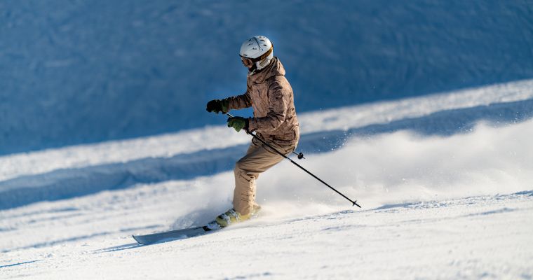 A skier skillfully navigates a snowy slope on skis, capturing the essence of winter fun in Whitefish, Montana.