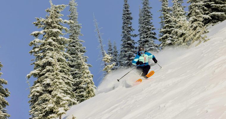 A skier descends a snow-covered slope in Whitefish, Montana, showcasing the thrill of winter sports and adventure at Whitefish Mountain Resort.