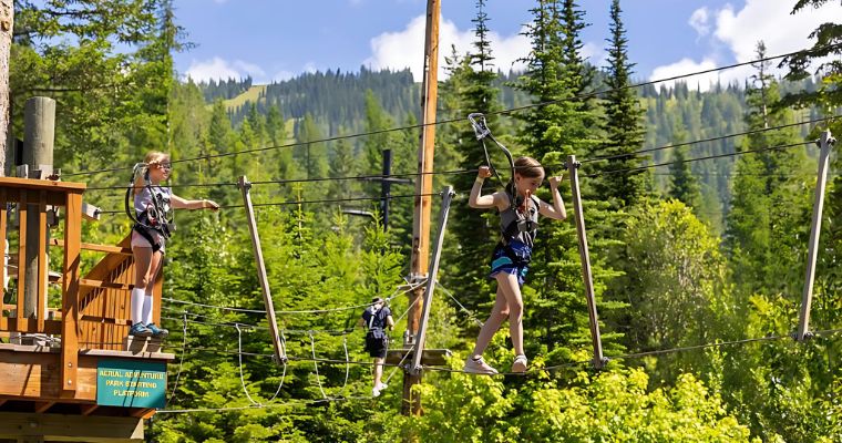 Two children enjoy the activities at Whitefish Aerial Adventure Park in Aspen in summer.