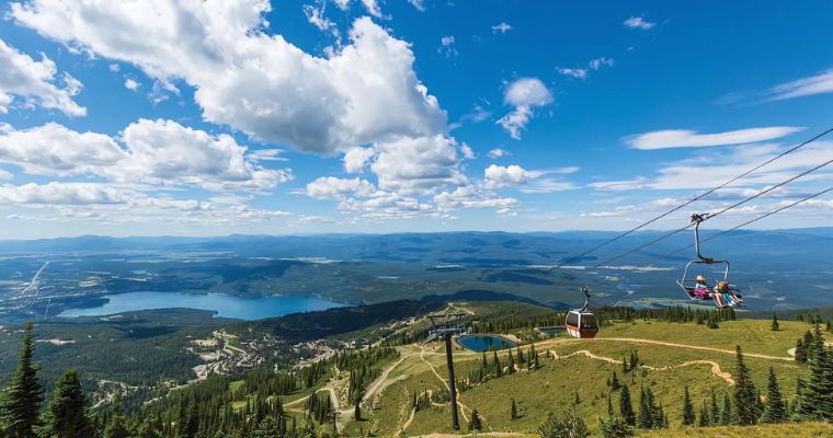 Scenic view of mountains and a lake from a gondola during a summer lift ride in Whitefish.