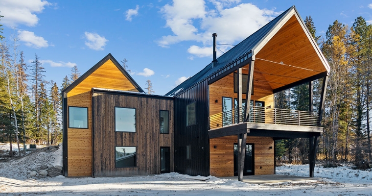 A modern home featuring a wooden roof and expansive deck, located at 158 Mountain Brook Lane, Whitefish build by Eco Residency.