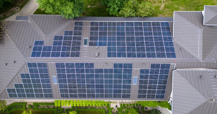 Aerial view of a luxury home in Whitefish featuring solar panels on the roof, highlighting eco-friendly design.