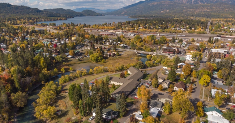 Scenic aerial shot of a small town in fall, with colorful trees framing the landscape, reflecting the essence of Whitefish.