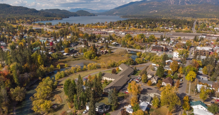 Scenic aerial shot of a small town during fall, emphasizing real estate development potential in Whitefish's landscape.