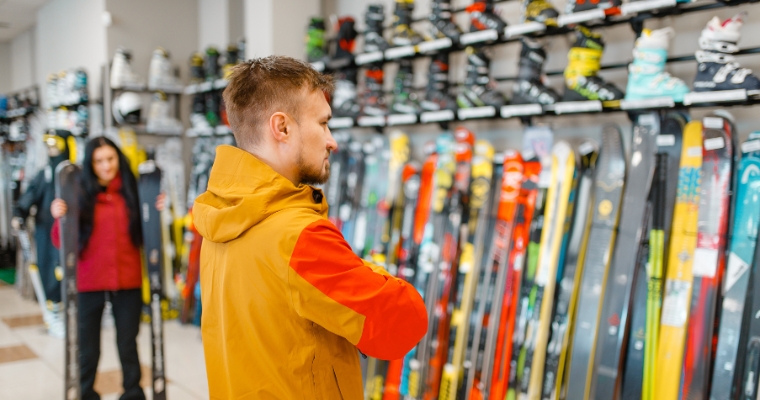 A man is shopping for skis at the Summit Shop in Whitefish, Montana, surrounded by various ski equipment.