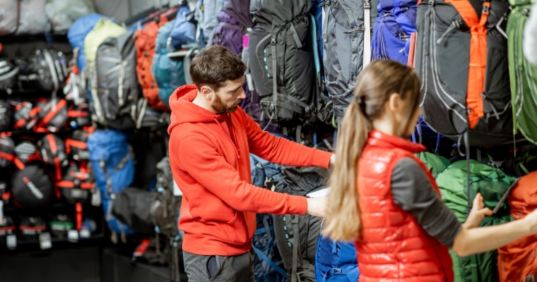 A couple browses backpacks at Rocky Mountain Outfitter in Whitefish, Montana, enjoying their shopping experience.