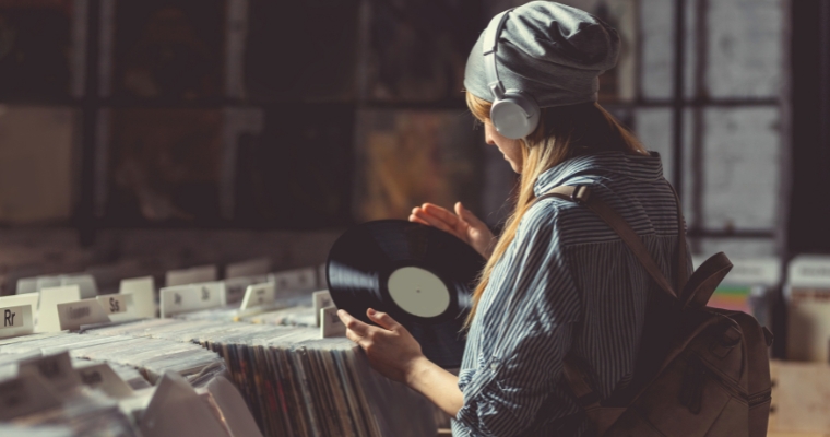 A woman in a hat and headphones browses vinyl records at Slow Burn Records in Whitefish, Montana.