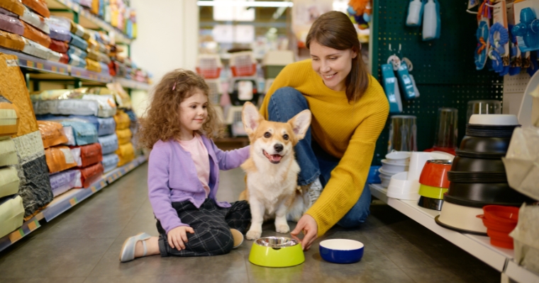A woman and a child gently pet a dog in Tailwaggers pet store in Whitefish, Montana, surrounded by pet supplies.