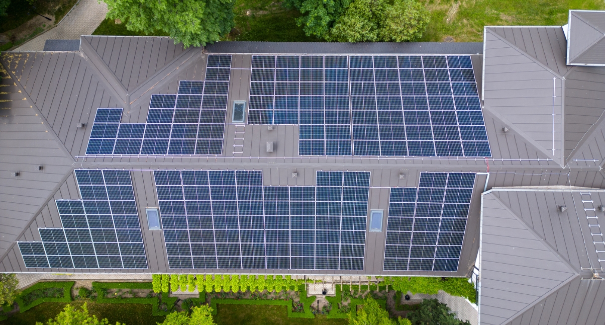 Aerial view of a large roof covered in solar panels, showcasing the custom modern homes Whitefish with energy systems.