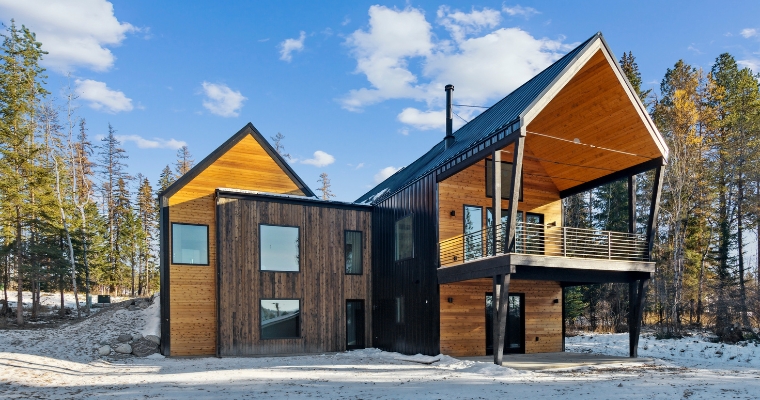 Modern cabin in snowy woods, showcasing Net-Zero Homes at 158 Mountain Brook Lane, Whitefish, Montana.