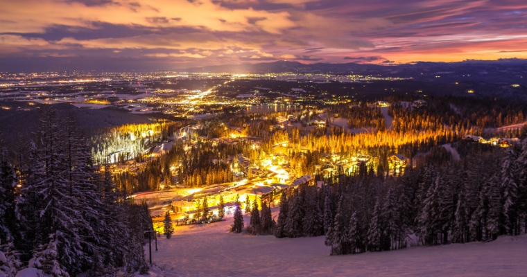 Night view of a ski resort in Whitefish, Montana, showcasing illuminated slopes and net-zero homes in the background.
