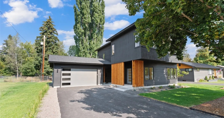 Contemporary home featuring black siding and a driveway, situated in eco-friendly neighborhood of downtown Whitefish, Montana.