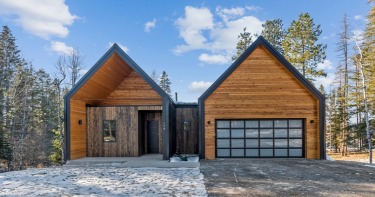 Modern home with wood exterior and two garages, located in downtown Whitefish, Montana, highlighting sustainability initiatives.