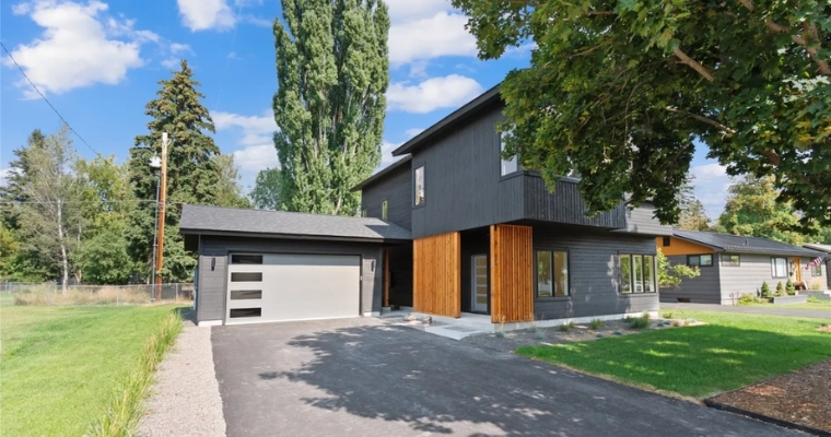 Sleek modern residence with black exterior and driveway, highlighting ownership structures for Whitefish second homes.