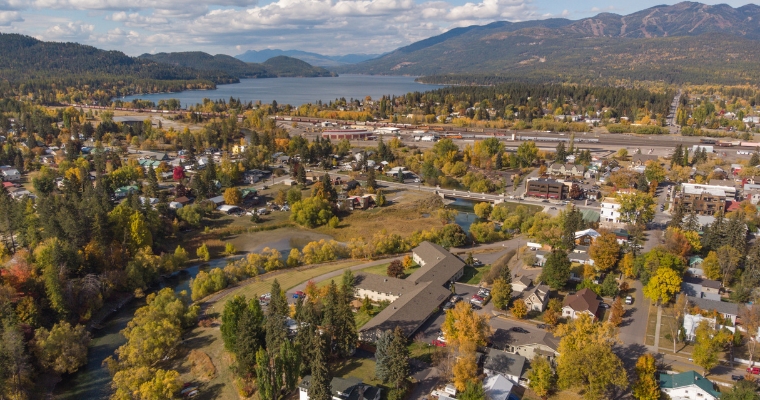 Aerial view of a small town surrounded by vibrant fall foliage, showcasing the charm of Whitefish in autumn.
